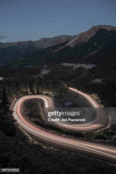 long exposure of traffic going up and over red mountain pass on the million dollar highway on a summer night - million dollar highway stock-fotos und bilder