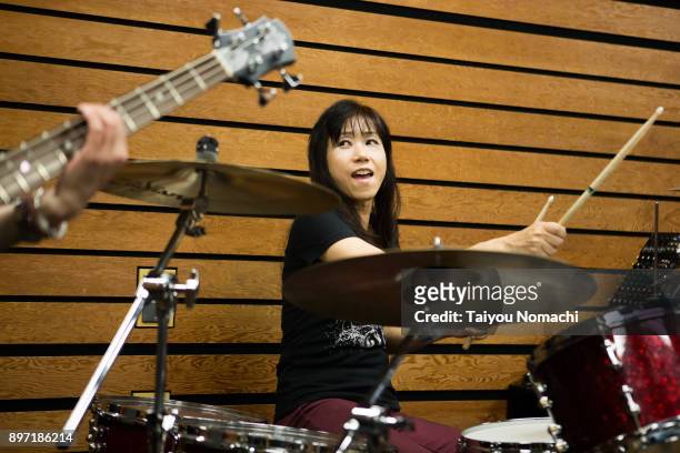 practice scene of female rock band - drummer stock-fotos und bilder