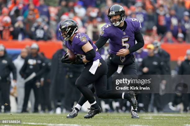 Joe Flacco of the Baltimore Ravens hands the ball off to Danny Woodhead of the Baltimore Ravens during the game against the Cleveland Browns at...