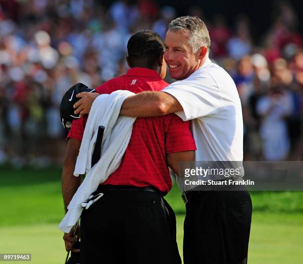 Tiger Woods of USA is congratulated by chis caddy Steve Williams on the 18th hole during the final round of the World Golf Championship Bridgestone...