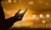 Silhouette of human hand with open palm praying to god