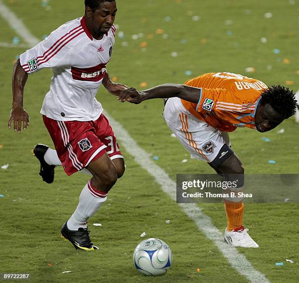Kei Kamara of the Houston Dynamo is tackled by Dasan Robinson of the Chicago Fire at Robertson Stadium on August 9, 2009 in Houston, Texas.
