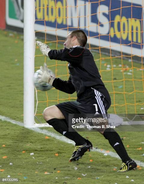 Goalie Jon Busch of the Chicago Fire tries to stop Stuart Holden's of the Houston Dynamo penalty at Robertson Stadium on August 9, 2009 in Houston,...