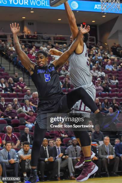 Buffalo Bulls guard CJ Massinburg sails toward the stanchion after losing control of the ball during a layup as Texas A&M Aggie center Tyler Davis...