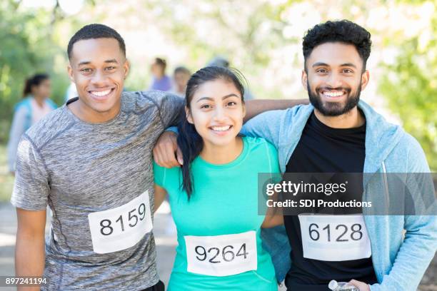 portrait of three friends before charity race together - sports bib stock pictures, royalty-free photos & images