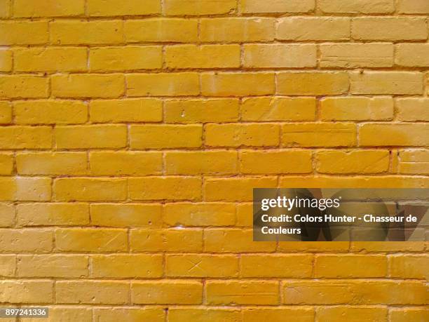 colored bricks wall - yellow wall stock-fotos und bilder