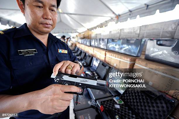 Thai Customs official inspects a fake BB gun during a press conference of the Thai Customs department in Bangkok on August 10, 2009. Thai Customs...