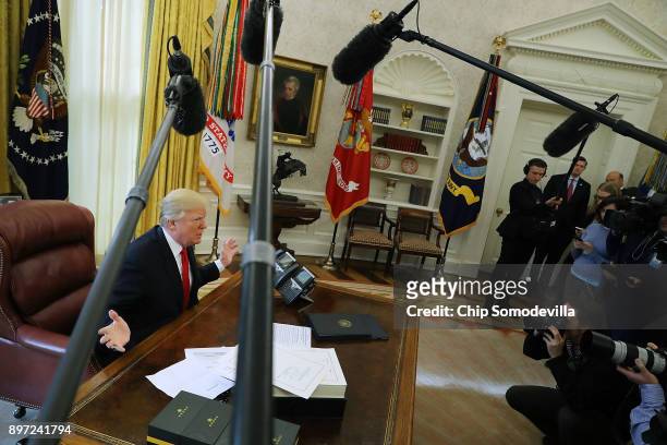 President Donald Trump talks with journalists before signing tax reform legislation into law in the Oval Office December 22, 2017 in Washington, DC....