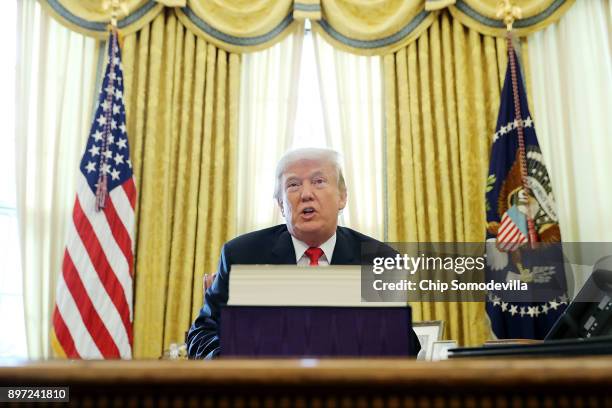 President Donald Trump talks with journalists after signing tax reform legislation into law in the Oval Office December 22, 2017 in Washington, DC....