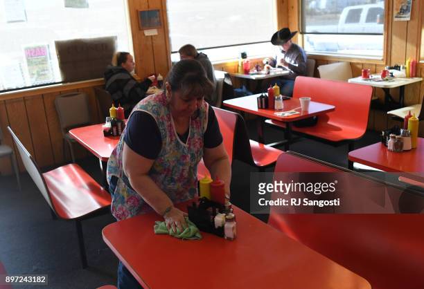 Elaine Vigil cleans a table at George's Drive-Inn Burgers, a restaurant she has worked at more than 20 years on December 20, 2017 in Walsenburg,...