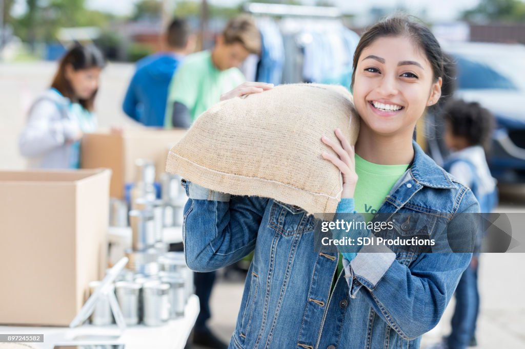 Young woman donates bag of food during food drive