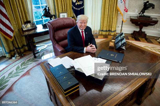 President Donald Trump waits to sign a continuing resolution bill and a tax reform bill in the Oval Office of the White House December 22, 2017 in...