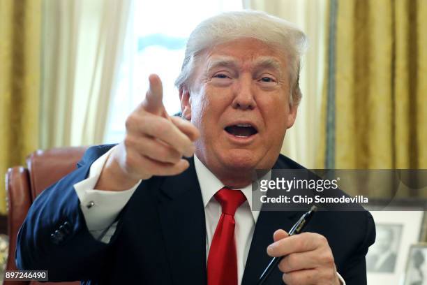 President Donald Trump talks with journalists after signing tax reform legislation into law in the Oval Office December 22, 2017 in Washington, DC....