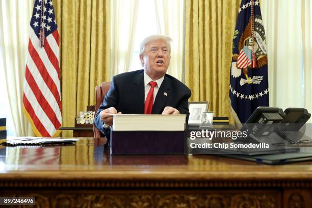 President Donald Trump talks with journalists after signing tax reform legislation into law in the Oval Office December 22, 2017 in Washington, DC....