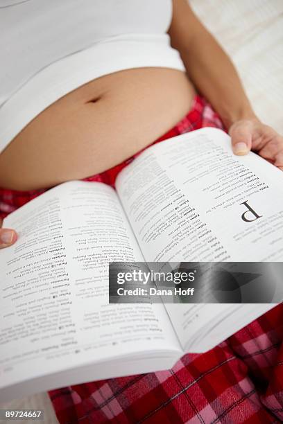 woman looks up baby names in baby book - 2008 fotografías e imágenes de stock