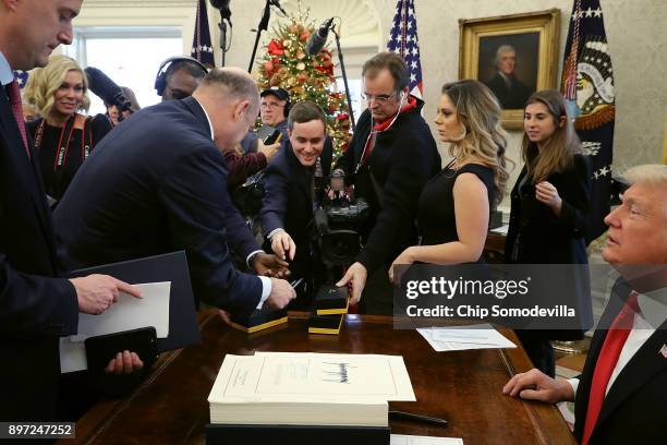 White House National Economic Council Director Gary Cohn helps hand out signing pens to journalists after U.S. President Donald Trump signed the tax...