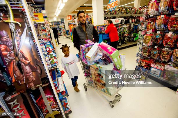 Neil Taylor joins the Hayden family from Kingstanding, Birmingham on a 'Supermarket Sweep' at the Toys 'R' Us Store on December 20, 2017 in Tamworth,...