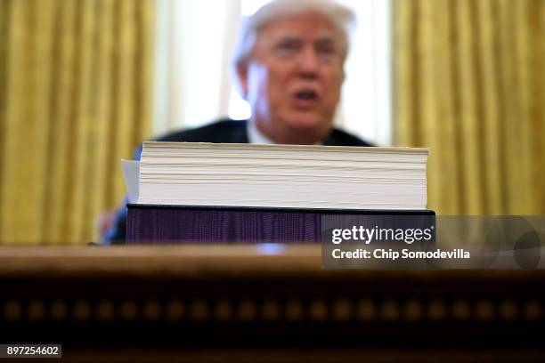 President Donald Trump talks with journalists after signing tax reform legislation into law in the Oval Office December 22, 2017 in Washington, DC....