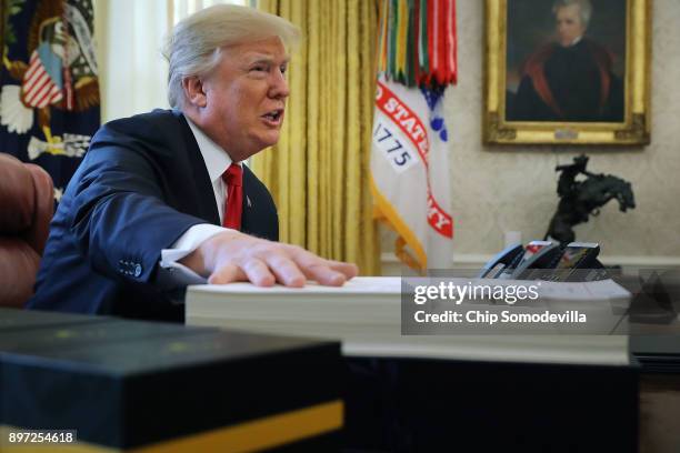 President Donald Trump talks with journalists before signing tax reform legislation into law in the Oval Office December 22, 2017 in Washington, DC....