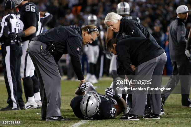 Donald Penn of the Oakland Raiders is comforted by head coach Jack Del Rio after getting injured in a play during the game against the Dallas Cowboys...