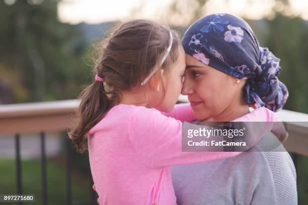 mother with cancer hugging daughter - cancer illness stock pictures, royalty-free photos & images