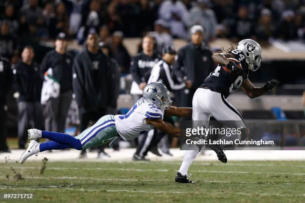Cordarrelle Patterson of the Oakland Raiders is tackled by Byron Jones of the Dallas Cowboys at Oakland-Alameda County Coliseum on December 17, 2017...
