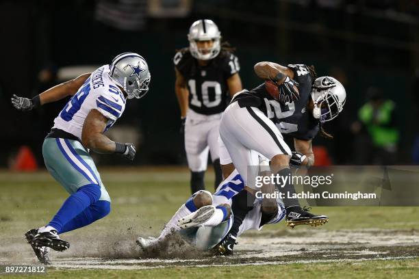 Marshawn Lynch of the Oakland Raiders is tackled by Xavier Woods of the Dallas Cowboys at Oakland-Alameda County Coliseum on December 17, 2017 in...