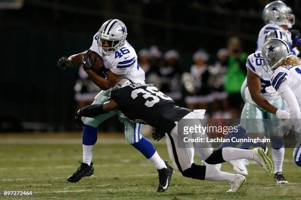 Alfred Morris of the Dallas Cowboys is tackled by TJ Carrie of the Oakland Raiders at Oakland-Alameda County Coliseum on December 17, 2017 in...