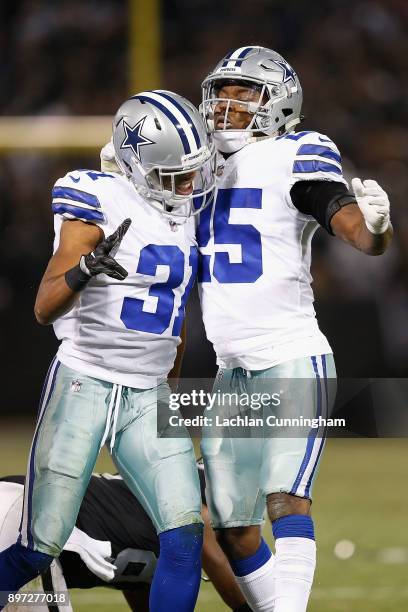 Byron Jones and Xavier Woods of the Dallas Cowboys celebrate after a defensive play against the Oakland Raiders at Oakland-Alameda County Coliseum on...