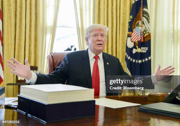 President Donald Trump speaks to members of the media before signing a tax-overhaul bill into law in the Oval Office of the White House in...