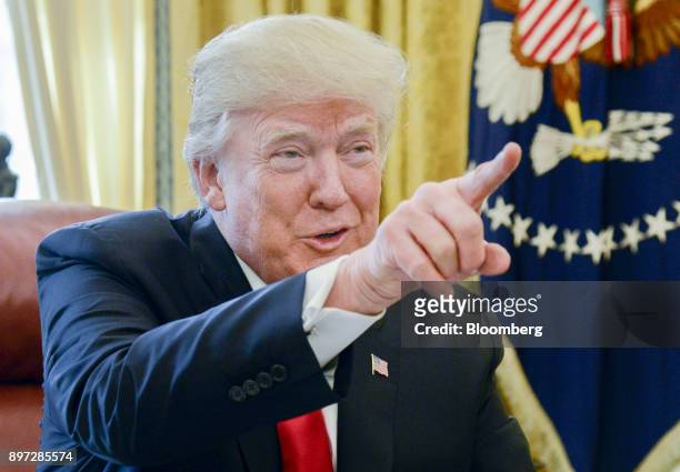 President Donald Trump speaks to members of the media before signing a tax-overhaul bill into law in the Oval Office of the White House in...