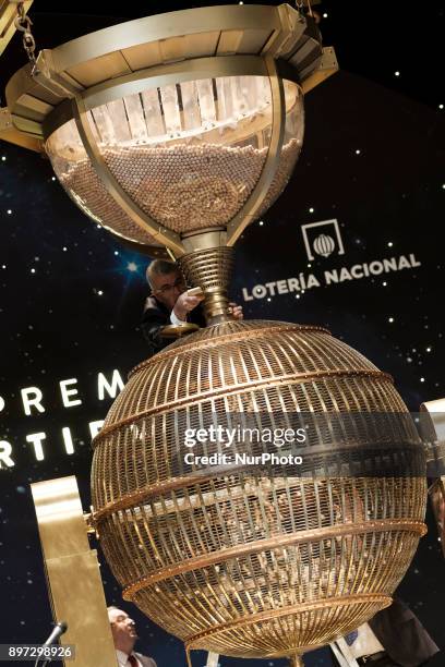 An official fills a drum with ball bearings of the lottery prizes during the draw of Spain's Christmas lottery named 'El Gordo' at the Teatro Real on...