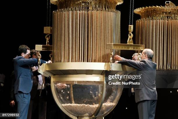 An official fills a drum with ball bearings of the lottery prizes during the draw of Spain's Christmas lottery named 'El Gordo' at the Teatro Real on...