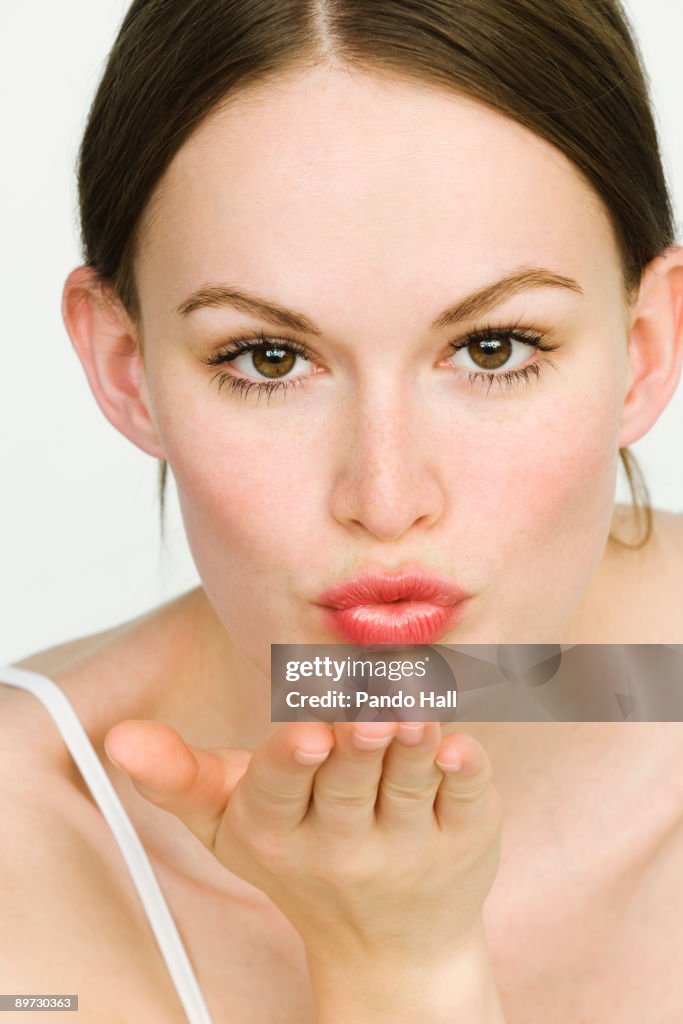 Young woman blowing kiss, close-up