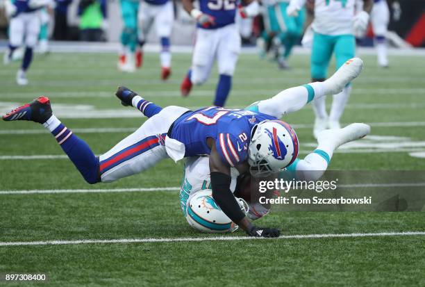 DeVante Parker of the Miami Dolphins is tackled by Tre'Davious White of the Buffalo Bills after hauling in a long pass during NFL game action at New...