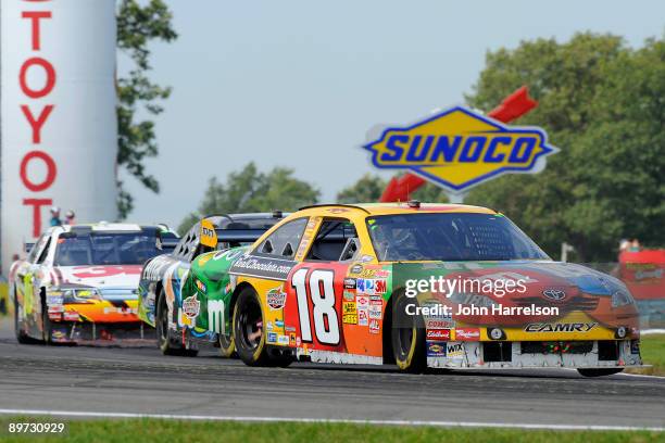 Kyle Busch driver of the M&M's Toyota races with Carl Edwards driver of the AFLAC Ford and Greg Biffle driver of the 3M Ford during the NASCAR Sprint...