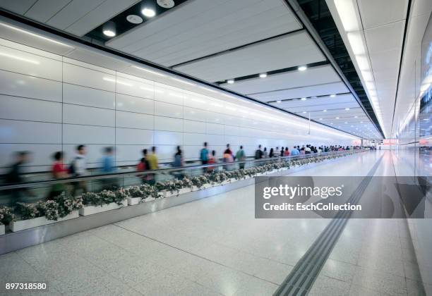 people using travelator at metro station in hong kong - rollender bürgersteig stock-fotos und bilder