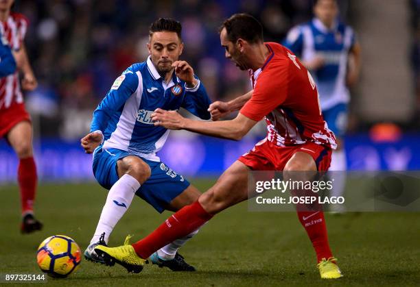 Atletico Madrid's Uruguayan defender Diego Godin vies with Espanyol's forward Sergio Garcia during the Spanish league football match RCD Espanyol vs...