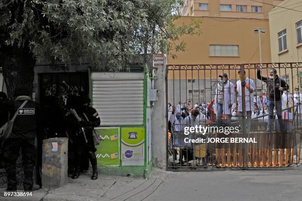 Medicine students find shelter from riot police inside the Mayor de San Andres University after clashes within a protest against a new law that...