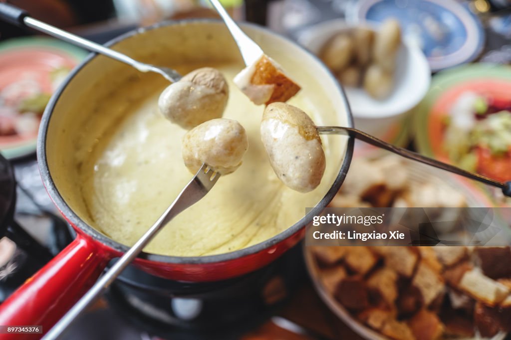 Classic Swiss cheese fondue with breads and potatoes, landmark of Switzerland