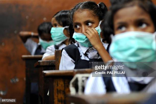 Indian school children, wearing protective masks distributed by the local right wing Shiv Sena party for an awareness campaign, are seen in a...