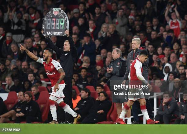 Theo Walcott comes on as a sub for Alexis Sanchez of Arsenal as Arsene Wenger the Arsenal Manager look on during the Premier League match between...