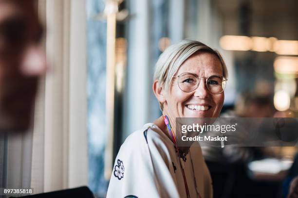portrait of smiling businesswoman in cafe - vrouw 50 jaar stockfoto's en -beelden