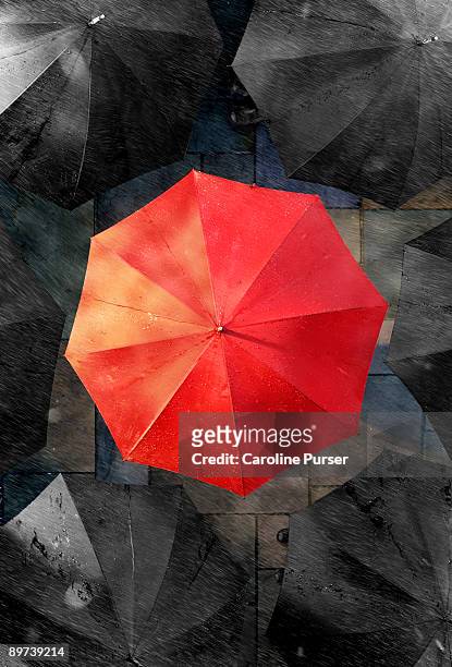 one red umbrella surrounded by black umbrellas - umbrellas from above photos et images de collection