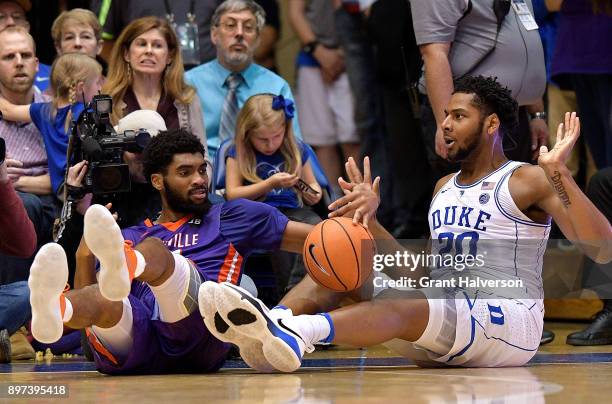 Riley of the Evansville Aces battles Marques Bolden of the Duke Blue Devils for a loose ball during their game at Cameron Indoor Stadium on December...