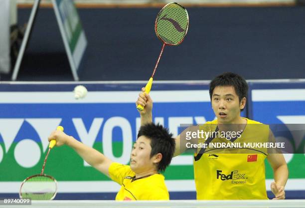 Yu Yang is watched by partner He Hanbin of China as he plays a shot against Jien Guo Ong and Sook Chin Chong of Malaysia during the mixed doubles...