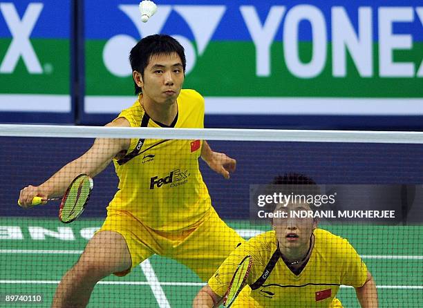 Yu Yang of China watches as partner He Hanbin plays a shot against Jien Guo Ong and Sook Chin Chong of Malaysia during their mixed doubles first...