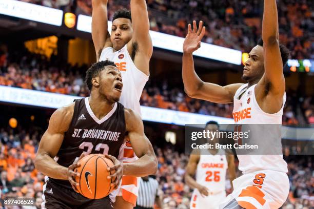 Josh Ayeni of the St. Bonaventure Bonnies pulls up to shoot under the basket as Matthew Moyer and Oshae Brissett of the Syracuse Orange defend during...