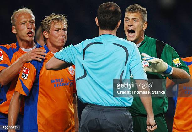Tim Sebastian and Kevin Schoeneberg of Rostock, referee Marco Fritz and Alexander Walke of Rostock discuss during the second Bundesliga match between...