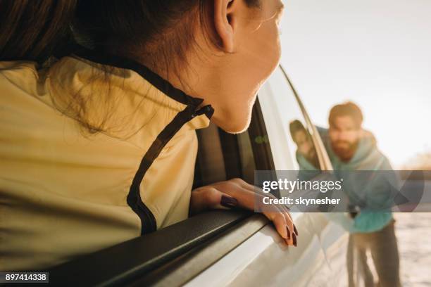 close up of a woman in broken car looking at men who is helping her. - car boken stock pictures, royalty-free photos & images